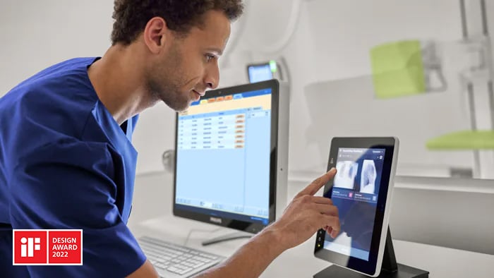 Radiólogo que utiliza un dispositivo inteligente compatible con IA para revisar los resultados de posicionamiento precisos de una radiografía