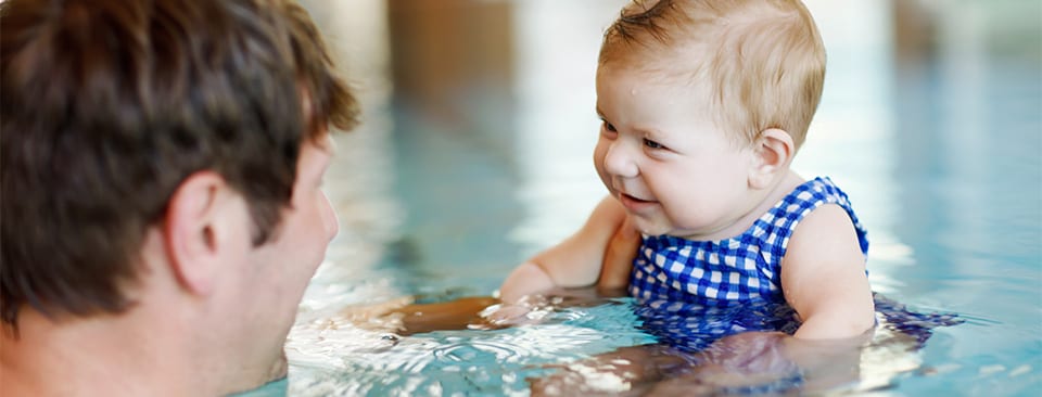 Un hombre y un bebé en una piscina