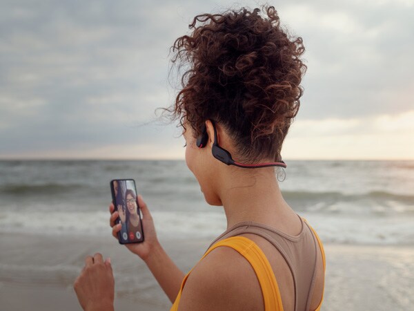 Mujer disfrutando de la función Crystal Call de los auriculares de conducción ósea de Philips