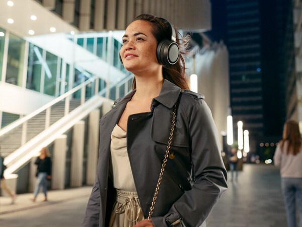 Mujer disfrutando de la comodidad de los auriculares Philips Fidelio al aire libre