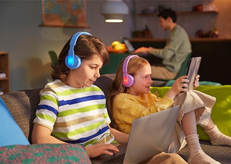 Niños utilizando la función de paneles luminosos de colores de los auriculares de diadema Philips