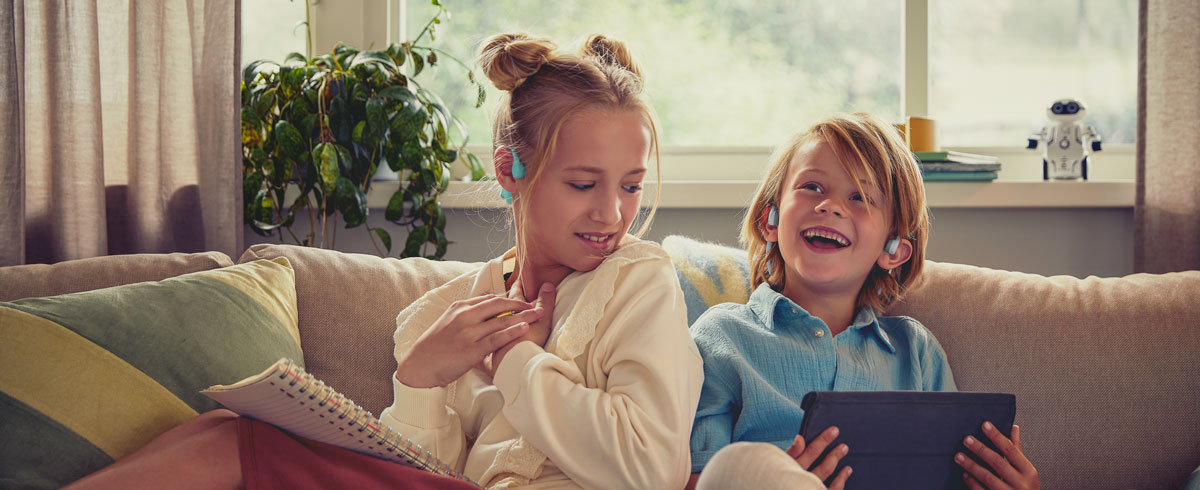 Niños viendo un vídeo con los auriculares abiertos para niños Philips