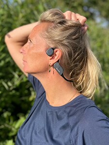 Mujer con los auriculares Bluetooth de conducción ósea de Philips