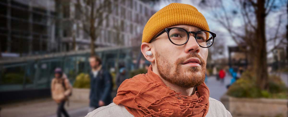 Foto de primer plano de un hombre con auriculares inalámbricos verdaderos