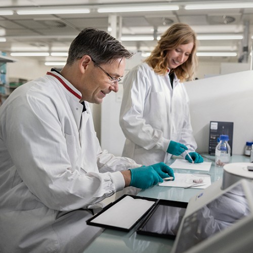 Un paciente hablando con un profesional dental con una l&aacute;mpara Philips Zoom! WhiteSpeed en el fondo