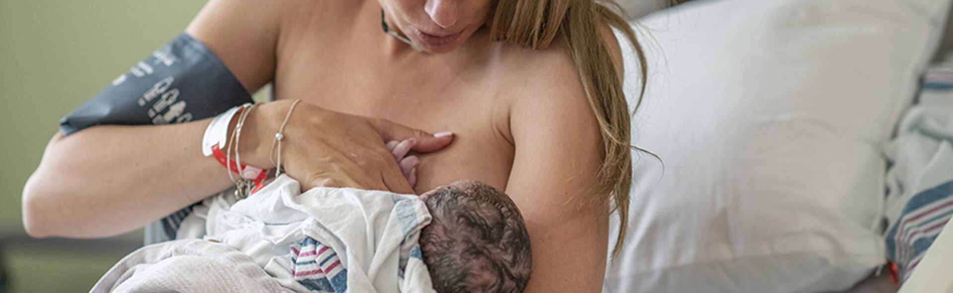 A baby sucking on their mom's breast