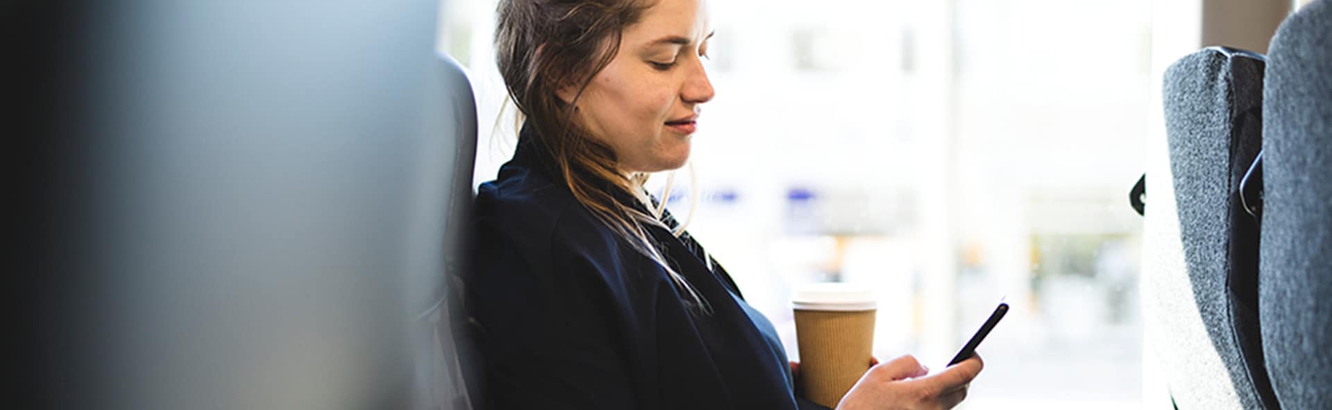 A pregnant woman looking at her phone while sitting down