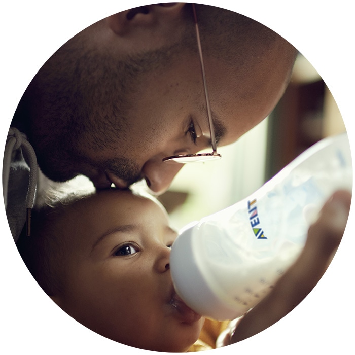 Dad bottle feeding child